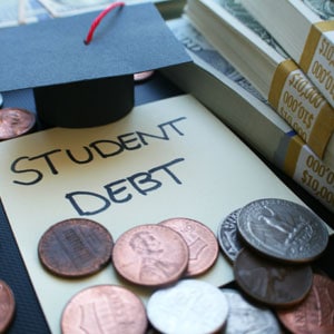 A small graduation cap and a sticky note with "STUDENT DEBT" written on it are surrounded by various coins and stacks of dollar bills - Nager Law Group