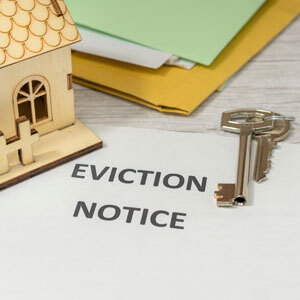 Eviction notice with house model, keys, and documents, representing housing and legal issues - Nager Law Group