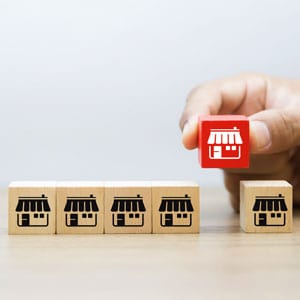 hand grips wooden blocks, prominently displaying a red block, symbolizing Short Sale concept