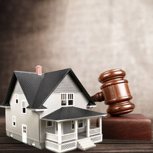 A gavel and a miniature house model, symbolizing foreclosure - Nager Law Group