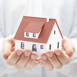 A miniature house model held in cupped hands, symbolizing Foreclosure